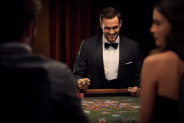 A woman in a luxurious green gown next to an ornate roulette wheel, capturing the upscale casino mood of JLMMM.